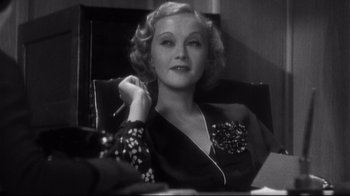 Movie still from “What Ever Happened to Baby Jane?” (1962), directed by Robert Aldrich – An older woman sitting in a chair holding a cigarette; Close Up shot, Low angle