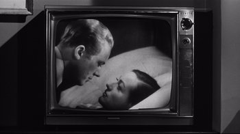 Movie still from “What Ever Happened to Baby Jane?” (1962), directed by Robert Aldrich – A man and a woman in bed on a television screen; Close Up shot, High angle
