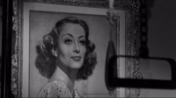 Movie still from “What Ever Happened to Baby Jane?” (1962), directed by Robert Aldrich – A black - and - white photo of a woman's face in front of a painting; Close Up shot, Low angle