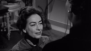 Movie still from “What Ever Happened to Baby Jane?” (1962), directed by Robert Aldrich – An old photo of an older woman smiling for the camera; Close Up shot, Over the shoulder angle