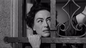 Movie still from “What Ever Happened to Baby Jane?” (1962), directed by Robert Aldrich – An old photo of a woman looking through a fence; Close Up shot, Low angle