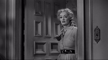 Movie still from “What Ever Happened to Baby Jane?” (1962), directed by Robert Aldrich – An older woman standing in front of a door; Medium shot, Low angle
