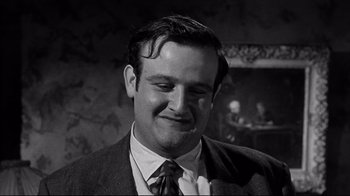 Movie still from “What Ever Happened to Baby Jane?” (1962), directed by Robert Aldrich – A black and white photo of a man in a suit; Close Up shot, Low angle