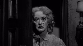 Movie still from “What Ever Happened to Baby Jane?” (1962), directed by Robert Aldrich – An older woman with a surprised look on her face; Medium shot, Low angle