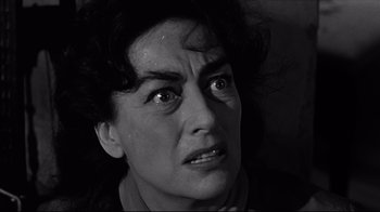 Movie still from “What Ever Happened to Baby Jane?” (1962), directed by Robert Aldrich – An old photo of a woman looking angry; Close Up shot, High angle
