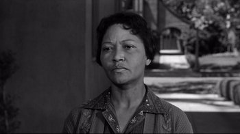 Movie still from “What Ever Happened to Baby Jane?” (1962), directed by Robert Aldrich – An old black and white photo of a woman with short black hair; Close Up shot, Low angle