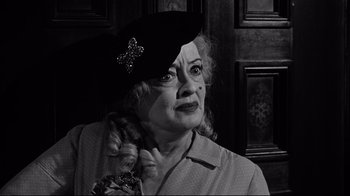 Movie still from “What Ever Happened to Baby Jane?” (1962), directed by Robert Aldrich – An older woman wearing a black hat with a star on it; Close Up shot, Over the shoulder angle