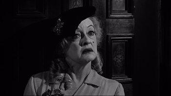Movie still from “What Ever Happened to Baby Jane?” (1962), directed by Robert Aldrich – An older woman wearing a black hat and a polka dot shirt; Close Up shot, Low angle