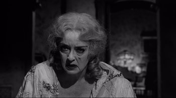 Movie still from “What Ever Happened to Baby Jane?” (1962), directed by Robert Aldrich – An old woman with a sad look on her face; Close Up shot, Low angle