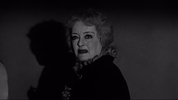 Movie still from “What Ever Happened to Baby Jane?” (1962), directed by Robert Aldrich – An older woman with a black jacket on; Close Up shot, Over the shoulder angle