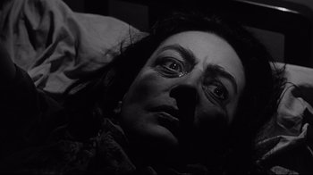 Movie still from “What Ever Happened to Baby Jane?” (1962), directed by Robert Aldrich – A woman laying in a bed with her eyes wide open; Close Up shot, Low angle