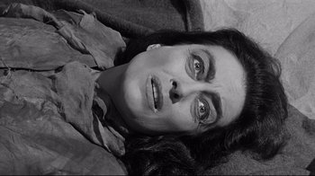 Movie still from “What Ever Happened to Baby Jane?” (1962), directed by Robert Aldrich – A woman laying on the ground with her eyes wide open; Close Up shot, High angle