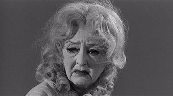 Movie still from “What Ever Happened to Baby Jane?” (1962), directed by Robert Aldrich – An old woman with a sad look on her face; Close Up shot, Low angle