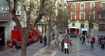 Movie still from “What Have I Done to Deserve This?” (1984), directed by Pedro Almodóvar – A group of people standing on the side of a road; Extreme Wide shot, High angle