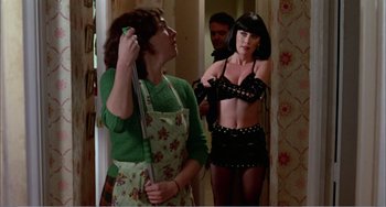 Movie still from “What Have I Done to Deserve This?” (1984), directed by Pedro Almodóvar – A woman in a black bra and a green apron; Medium shot, Low angle