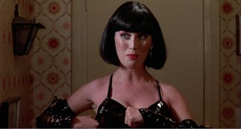 Movie still from “What Have I Done to Deserve This?” (1984), directed by Pedro Almodóvar – A woman in a black bra and black gloves; Close Up shot, Low angle