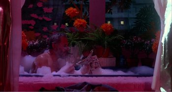 Movie still from “What Have I Done to Deserve This?” (1984), directed by Pedro Almodóvar – A man is in a bath tub with a glass of wine; Wide shot, High angle