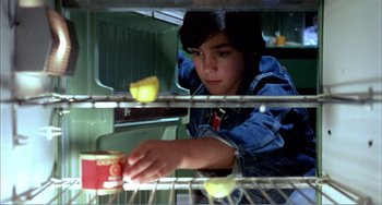 Movie still from “What Have I Done to Deserve This?” (1984), directed by Pedro Almodóvar – A young boy looking in the oven at some food; Close Up shot, Low angle