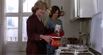 Movie still from “What Have I Done to Deserve This?” (1984), directed by Pedro Almodóvar – Two women in a kitchen preparing a meal together; Medium shot, Low angle