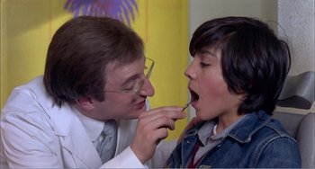 Movie still from “What Have I Done to Deserve This?” (1984), directed by Pedro Almodóvar – A doctor examines a young boy's teeth; Close Up shot, Low angle