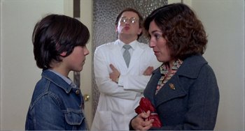 Movie still from “What Have I Done to Deserve This?” (1984), directed by Pedro Almodóvar – A woman and a man are talking to a young boy; Medium shot, Over the shoulder angle