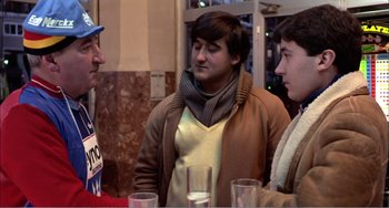 Movie still from “What Have I Done to Deserve This?” (1984), directed by Pedro Almodóvar – A group of people standing around a table; Medium shot, Over the shoulder angle