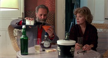 Movie still from “What Have I Done to Deserve This?” (1984), directed by Pedro Almodóvar – An older man and a woman sitting at a table; Medium shot, High angle