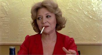 Movie still from “What Have I Done to Deserve This?” (1984), directed by Pedro Almodóvar – A woman in a red shirt is smoking a cigarette; Close Up shot, Low angle