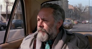 Movie still from “What Have I Done to Deserve This?” (1984), directed by Pedro Almodóvar – An older man with a gray beard driving in a car; Close Up shot, High angle