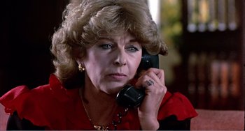 Movie still from “What Have I Done to Deserve This?” (1984), directed by Pedro Almodóvar – An older woman talking on a phone while wearing a red shirt; Close Up shot, Low angle