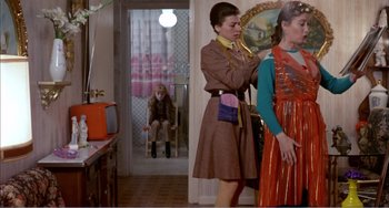Movie still from “What Have I Done to Deserve This?” (1984), directed by Pedro Almodóvar – A woman in a brown dress is looking at a woman in a red dress; Medium shot, Over the shoulder angle