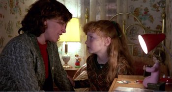 Movie still from “What Have I Done to Deserve This?” (1984), directed by Pedro Almodóvar – A woman and a girl sitting on a bed talking to each other; Medium shot, Over the shoulder angle