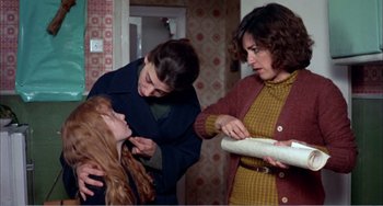 Movie still from “What Have I Done to Deserve This?” (1984), directed by Pedro Almodóvar – Two women and a young girl are looking at a piece of paper; Medium shot, Over the shoulder angle