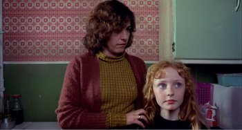 Movie still from “What Have I Done to Deserve This?” (1984), directed by Pedro Almodóvar – A woman standing next to a young girl in front of a window; Medium shot, Over the shoulder angle