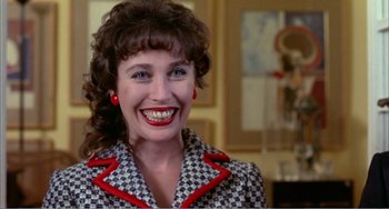 Movie still from “What Have I Done to Deserve This?” (1984), directed by Pedro Almodóvar – A woman with red lipstick smiles for the camera; Close Up shot, Low angle