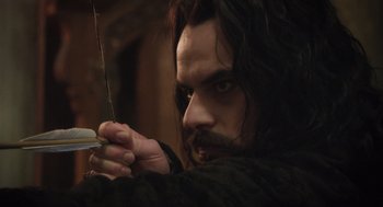 Movie still from “What We Do in the Shadows” (2014), directed by Taika Waititi – A person holding a sword; Close Up shot, Over the shoulder angle