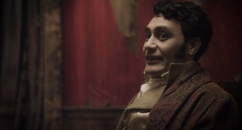 Movie still from “What We Do in the Shadows” (2014), directed by Taika Waititi – A wax statue of a man in a period costume; Close Up shot, Over the shoulder angle