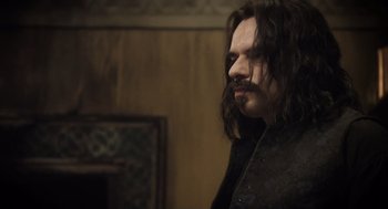 Movie still from “What We Do in the Shadows” (2014), directed by Taika Waititi – A person with long black hair; Close Up shot, Over the shoulder angle