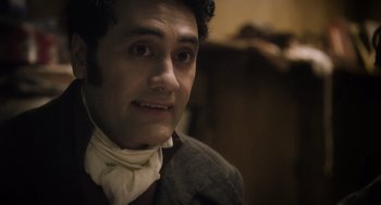 Movie still from “What We Do in the Shadows” (2014), directed by Taika Waititi – A person wearing a suit and tie; Close Up shot, Over the shoulder angle