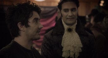 Movie still from “What We Do in the Shadows” (2014), directed by Taika Waititi – Two men are dressed up and looking at each other; Close Up shot, Over the shoulder angle