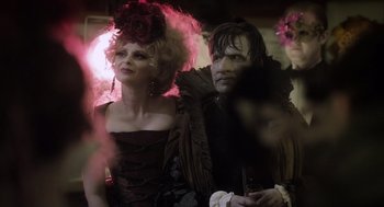 Movie still from “What We Do in the Shadows” (2014), directed by Taika Waititi – A man and a woman dressed up in costumes; Medium shot, Over the shoulder angle