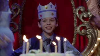 Movie still from “What Women Want” (2000), directed by Nancy Meyers – A young boy wearing a paper crown sitting in front of a birthday cake; Close Up shot, High angle