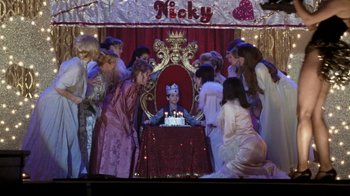 Movie still from “What Women Want” (2000), directed by Nancy Meyers – A group of people gathered around a birthday cake; Wide shot, High angle