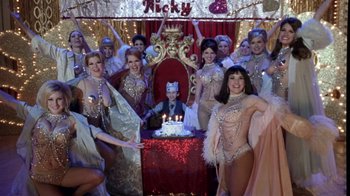 Movie still from “What Women Want” (2000), directed by Nancy Meyers – A group of women in costumes around a cake; Wide shot, High angle
