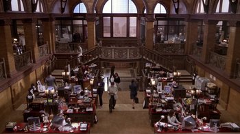 Movie still from “What Women Want” (2000), directed by Nancy Meyers – People are standing in a large room filled with books; Extreme Wide shot, High angle