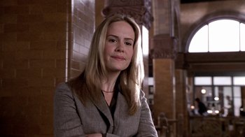 Movie still from “What Women Want” (2000), directed by Nancy Meyers – A woman in a gray suit posing for a picture; Close Up shot, Low angle