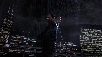 Movie still from “What Women Want” (2000), directed by Nancy Meyers – A man in a black suit is standing in the rain; Medium shot, Low angle