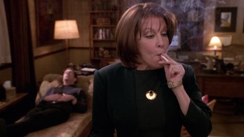 Movie still from “What Women Want” (2000), directed by Nancy Meyers – A woman in a black dress is smoking a cigarette; Medium shot, Over the shoulder angle