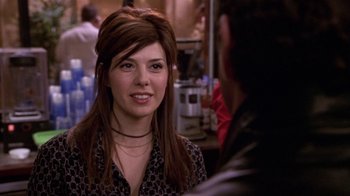 Movie still from “What Women Want” (2000), directed by Nancy Meyers – A woman with long brown hair wearing a black and white polka dot shirt; Close Up shot, Over the shoulder angle