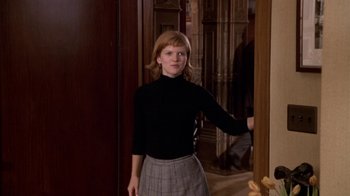 Movie still from “What Women Want” (2000), directed by Nancy Meyers – A woman in a black shirt and a gray skirt; Medium shot, Low angle